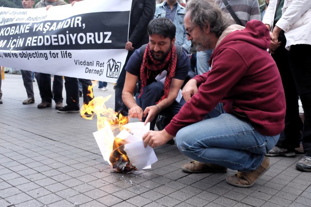 Türkiye’nin ilk vicdani retçilerinden 51 yaşındaki Vedat Zencir ve Ercan Aktaş, toplantının ardından Galatasaray Meydanı’nda Kobane direnişini destekleyen ret açıklamalarını okuduktan sonra kendilerine verilen GBT tutanaklarını yaktı